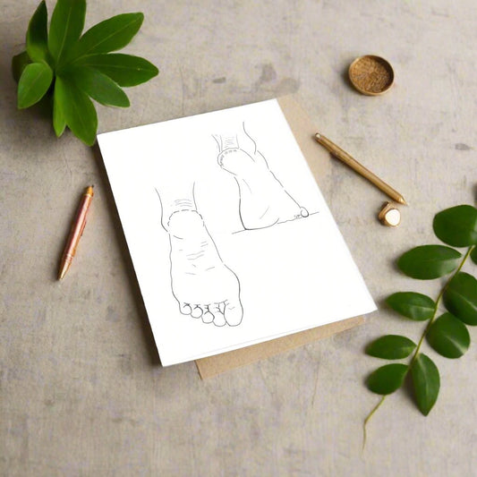 A set of blank Christian greeting cards with an illustration of feet on a table, surrounded by a plant, pencils, and a protractor.