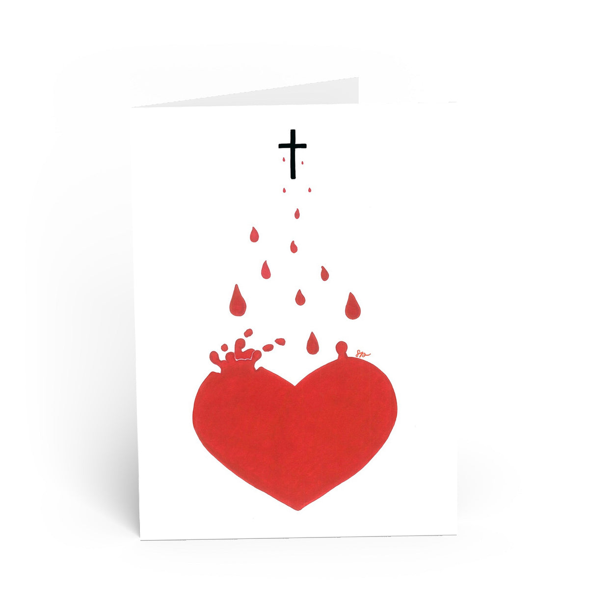 A white greeting card with a minimalist graphic of a red heart, red blood droplets, a small black cross, and splatter details, photographed on a clean white background.