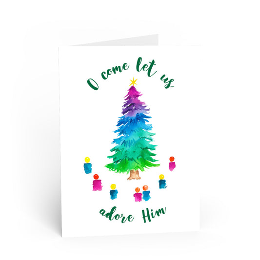 Colorful watercolor Christmas tree with star on top and people around the tree with the phrase “o come let us adore Him” on a white card
