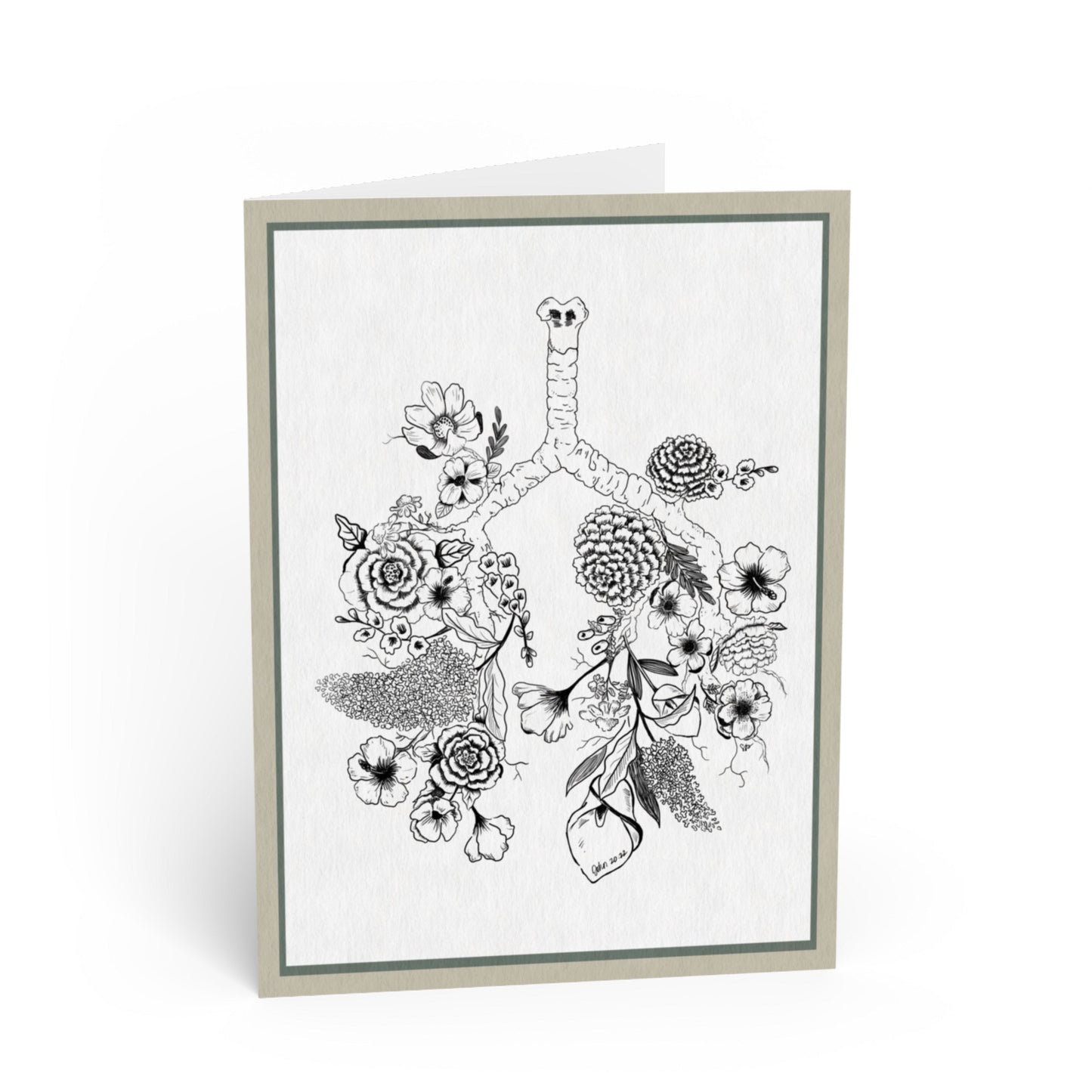 A folded greeting card standing upright, featuring a black-and-white botanical illustration of lungs surrounded by flowers and leaves. The card has a light gray border and is photographed on a clean white background.