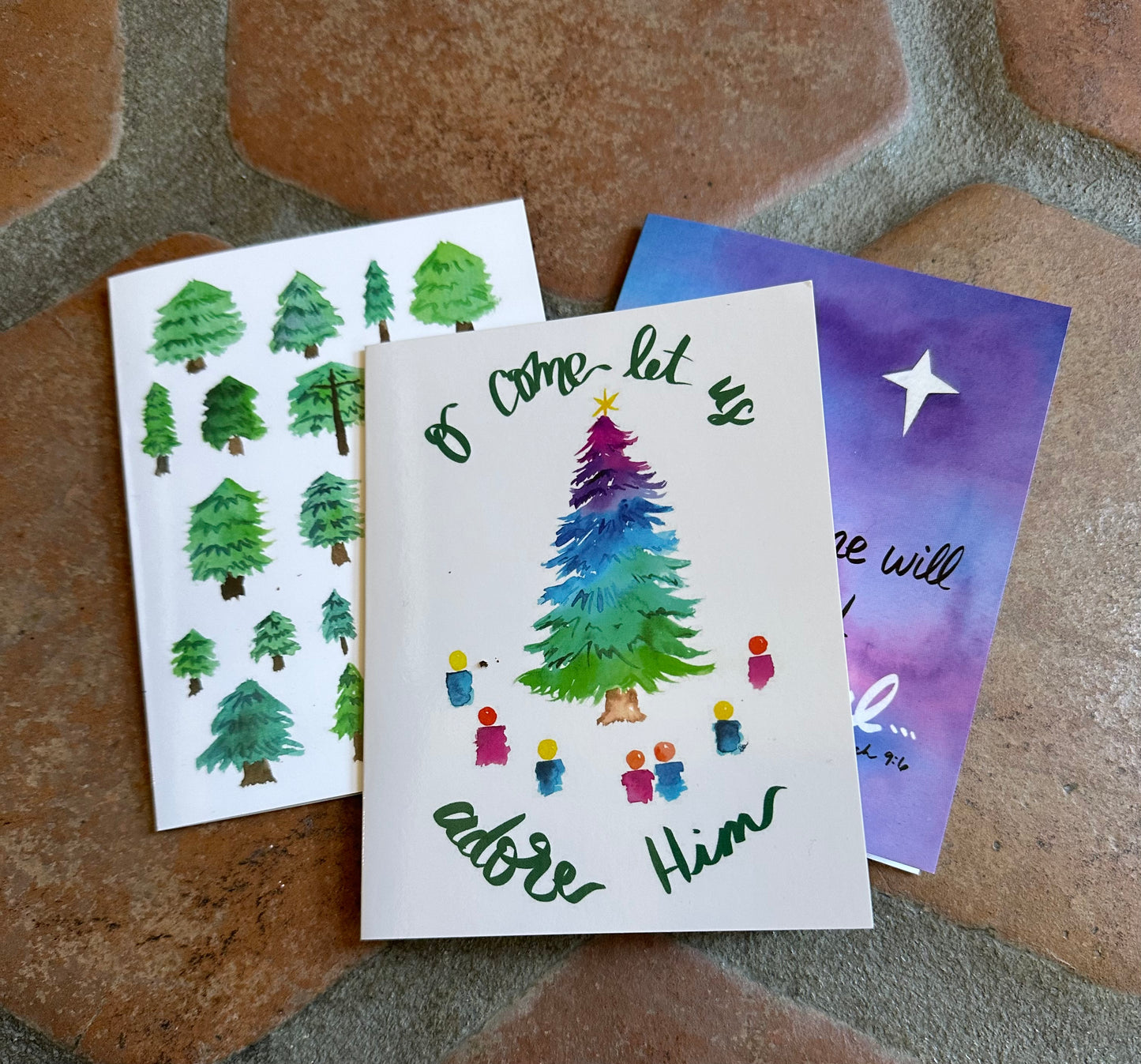 Three Christmas-themed cards on a textured surface