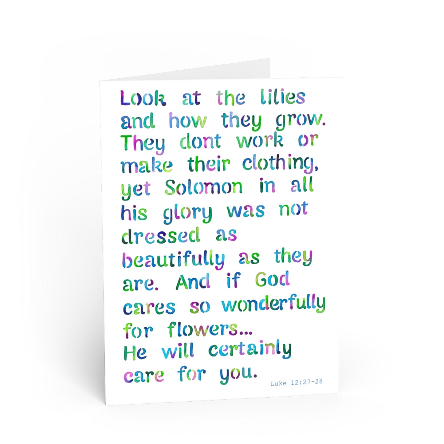 A white greeting card with colorful, hand-lettered text quoting Luke 12:27-28 Solomon and lilies, photographed on a clean white background.