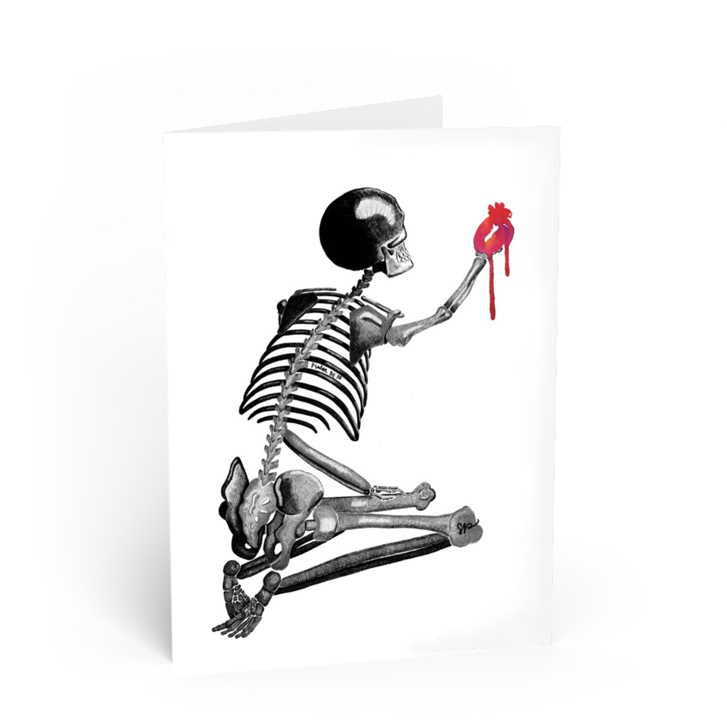 A white greeting card featuring a black and white illustration of a skeleton holding a dripping red heart, shown standing against a white background.