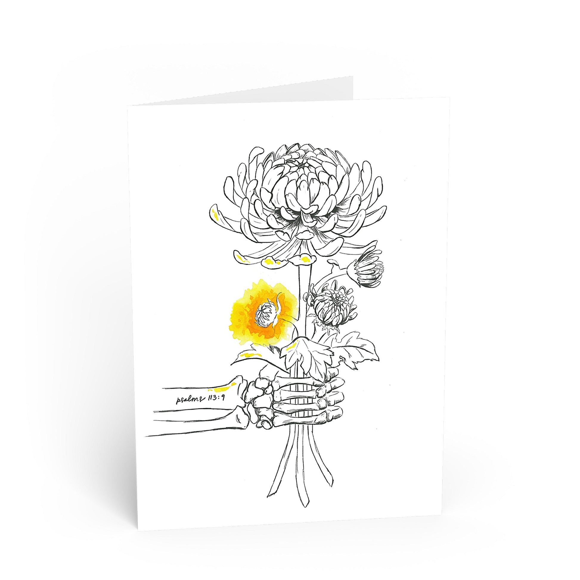A white greeting card standing upright on a white background, featuring a black line art illustration of a skeleton hand holding flowers, with one flower highlighted in bright yellow. The card has a small printed signature and date near the bottom left of the illustration.